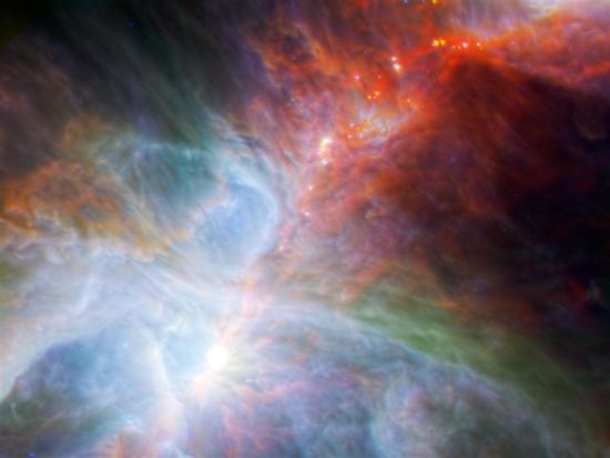 这是猎户座大星云的照片，综合了斯皮策和赫歇尔望远镜的红外波段观测数据，揭示出很多原本隐藏在尘埃气体云之中新生恒星的光芒，它们的星光璀璨，宛若宇宙彩虹
